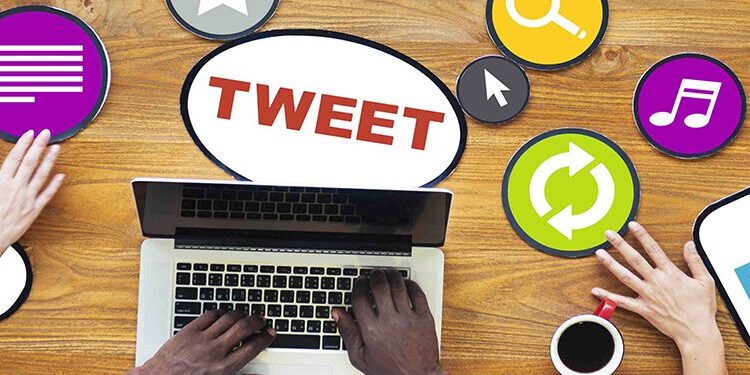 Two people use a laptop surrounded by colorful social media icons and speech bubbles labeled "TWEET," "LIKE," and "MEDIA" on a wooden table.