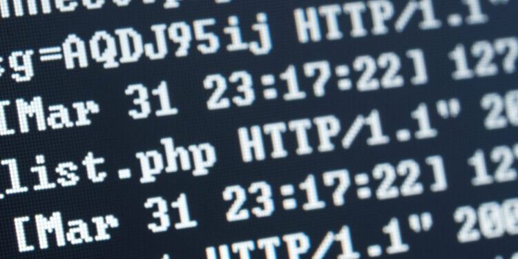 A computer screen displays lines of server log data, showing timestamps, HTTP requests, and file paths in a terminal window.