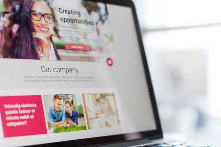 A laptop screen displays a website with sections titled "Creating opportunities" and "Our company," featuring images of people and text blocks.