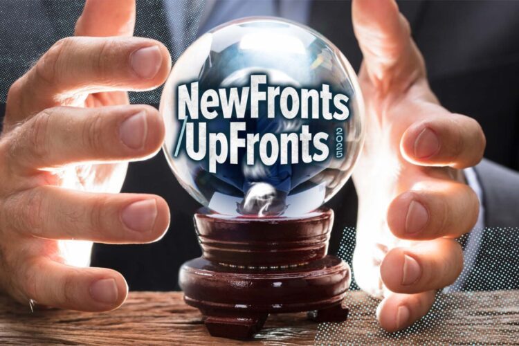 A person holds a crystal ball with the words "NewFronts UpFronts" inside, resting on a wooden surface.