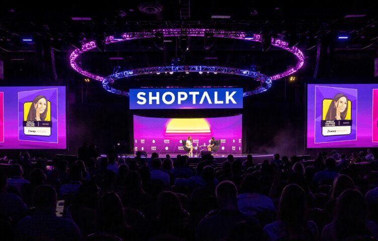 A large audience attends a panel discussion on stage at a SHOPTALK event, with speakers' portraits and names displayed on large screens under purple lighting.