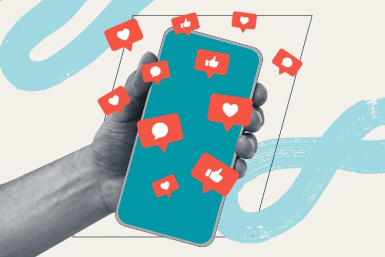 A hand holds a smartphone displaying floating social media notification icons, such as hearts, thumbs up, and speech bubbles.