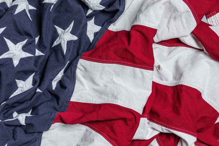 A close-up of a crumpled American flag showing white stars on a blue field and red and white stripes.