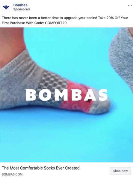Two feet wearing colorful Bombas socks against a blue background, with promotional text offering 20% off first purchase using code COMFORT20.