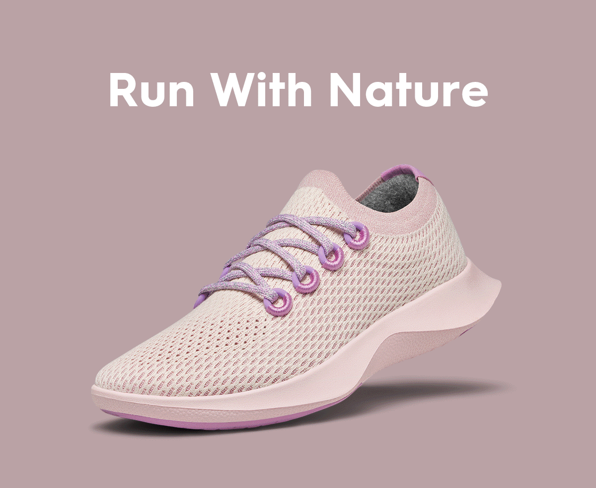 A light pink mesh running shoe with purple laces is displayed on a matching pink background with the text "Run With Nature" above it.
