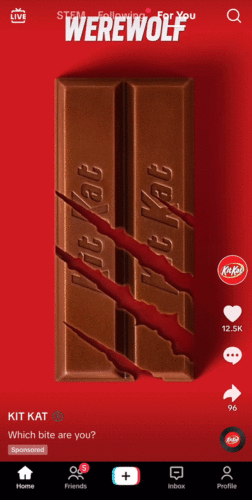 A Kit Kat bar with three claw marks across it on a red background, promoting the theme "Which bite are you?" in a sponsored social media post.