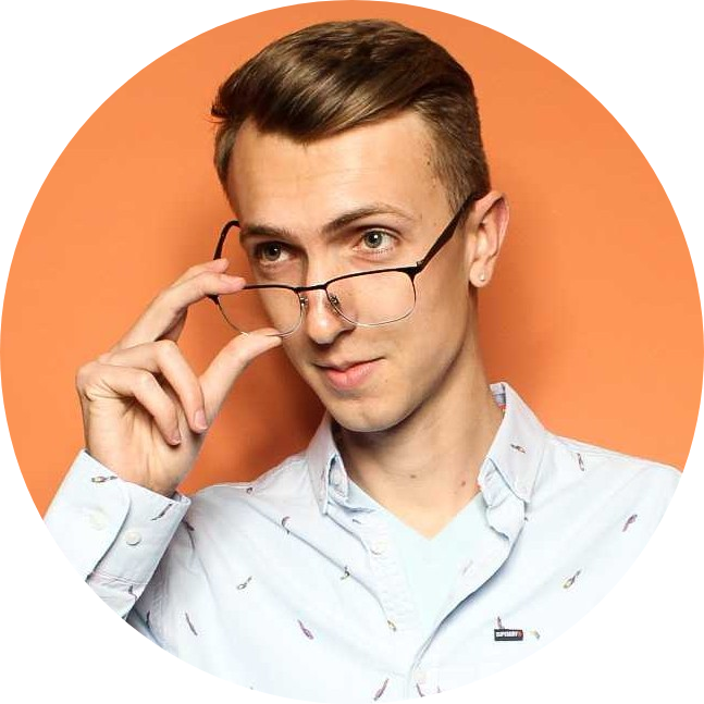 A person with short light brown hair wearing a light blue button-up shirt adjusts their glasses while looking slightly to the side against an orange background.