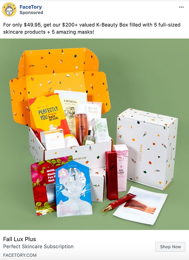 Open box displaying various skincare products and face masks from the FaceTory Fall Lux Plus K-Beauty Box, arranged on a green surface.