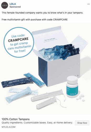 Open box containing blue and white tampon packages, two tampons with applicators, a bottle of multivitamins, and a card promoting a free gift with code CRAMPCARE.