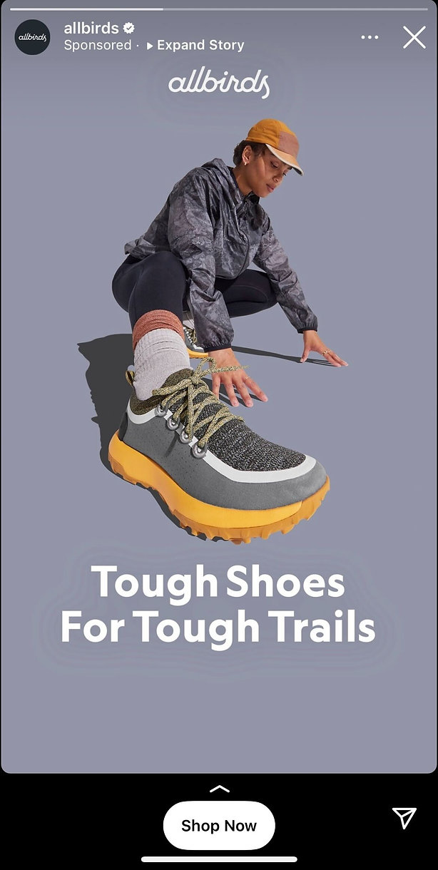 A person in outdoor clothing kneels to tie the laces of a gray and yellow Allbirds trail shoe. Text reads, "Tough Shoes For Tough Trails.
