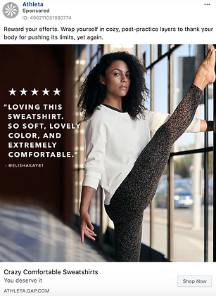 Woman in a white sweatshirt and patterned leggings stretches her leg on a barre in a brightly lit studio. Text overlay promotes the softness and comfort of the sweatshirt.