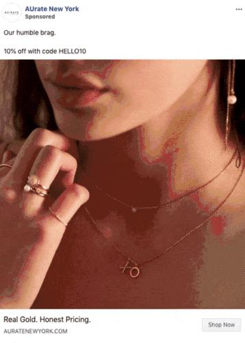 Close-up of a woman wearing gold jewelry, including hoop earrings, layered necklaces, and rings. Text overlay offers 10% off with code HELLO10 from AUrate New York.
