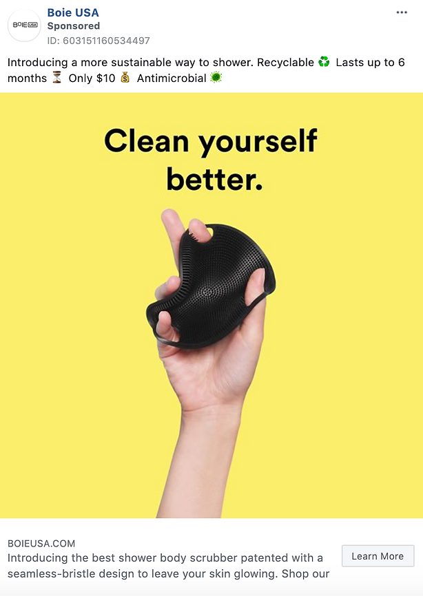 Hand holding a black textured shower body scrubber against a yellow background with the text "Clean yourself better." displayed above.