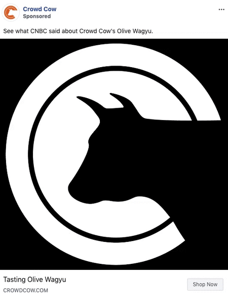 A black silhouette of a cow's head is centered within a bold, white, circular outline on a solid black background.