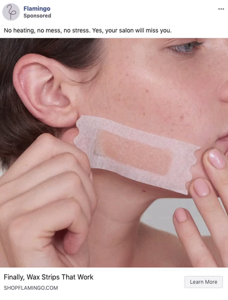 A person applies a wax strip to their cheek, preparing for hair removal.