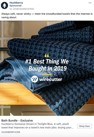 A close-up of dark blue textured towels stacked on a wooden surface, with text highlighting a Wirecutter recommendation.