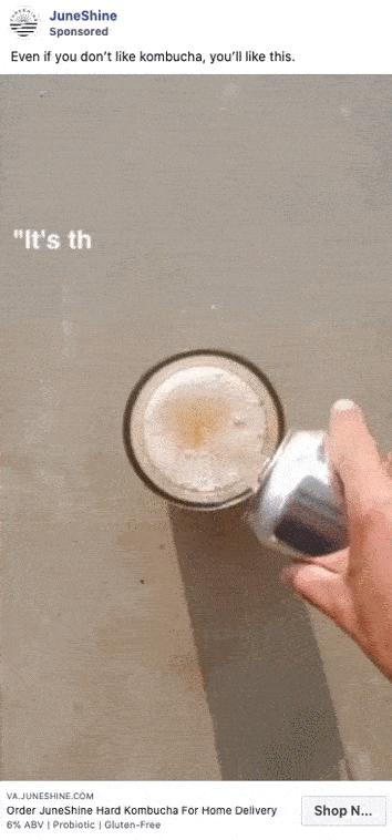 A hand pours a canned drink into a glass filled with a light, foamy beverage, with text above promoting JuneShine hard kombucha.