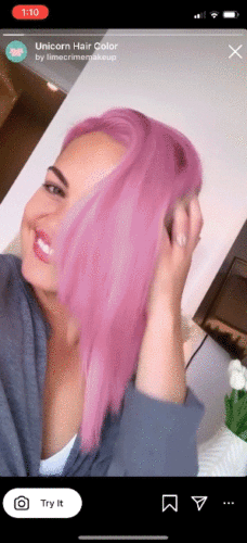 A woman with pink hair smiling.