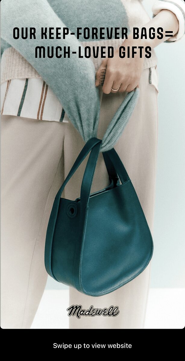 A person holds a blue handbag with one hand while wearing a light sweater and beige pants. Text on the image promotes Madewell's "keep-forever bags" as gift ideas.