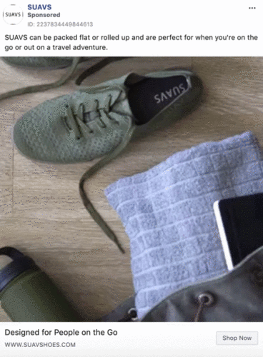 A pair of SUAVS green shoes, a gray textured pouch, and a partially visible laptop are arranged on a flat surface next to a green jacket.