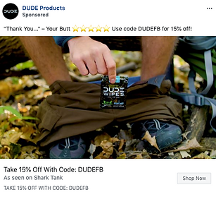 A person sitting outdoors with pants pulled down holds a packet of DUDE Wipes. Promotional text offers 15% off with the code DUDEFB.