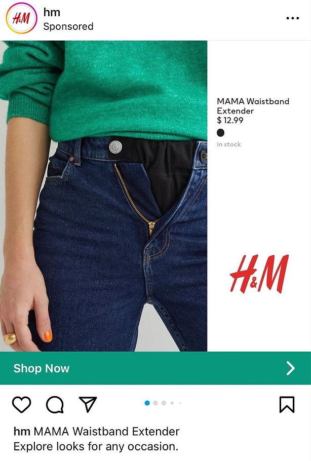 Person wearing blue jeans with waistband extender and green sweater, showing unbuttoned jeans with black extender piece. H&M logo and product details are visible on the right.