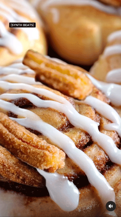 Close-up of cinnamon rolls topped with white icing and churros, with a [SYNTH BEATS] caption in the top left corner.