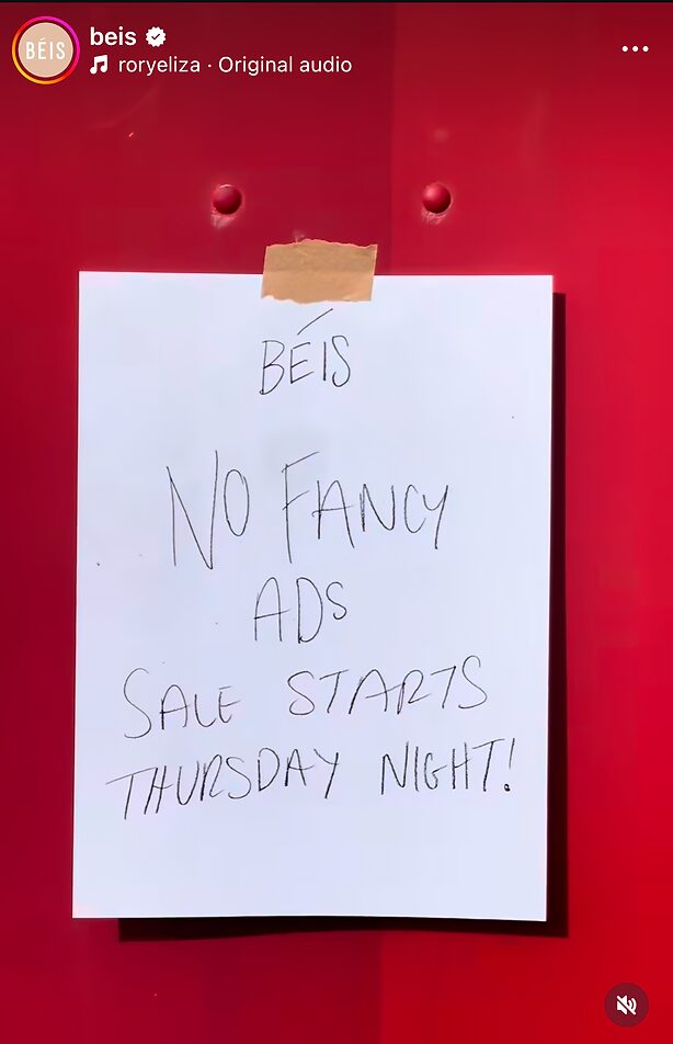 A handwritten sign on a red wall reads: "BEIS No fancy ads. Sale starts Thursday night!.