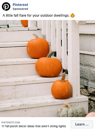 Four orange pumpkins are arranged on the white steps of an outdoor stairway, with part of a greenish-gray pumpkin visible at the bottom.