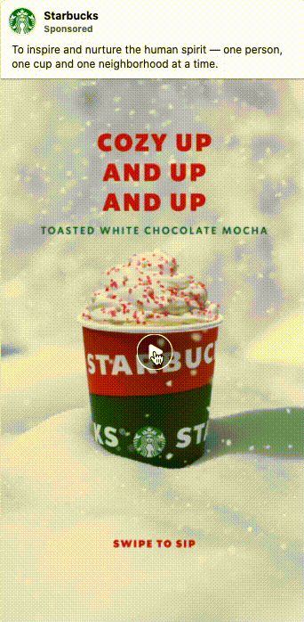 A Starbucks cup filled with toasted white chocolate mocha topped with whipped cream and red sprinkles, sitting on a snowy surface. Text reads: "COZY UP AND UP AND UP.