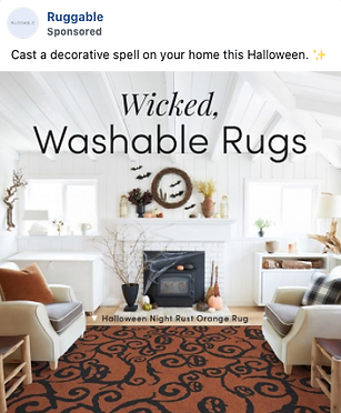 A living room decorated for Halloween features an orange and black patterned rug, white walls, and seasonal decorations above a fireplace. Text reads "Wicked, Washable Rugs.