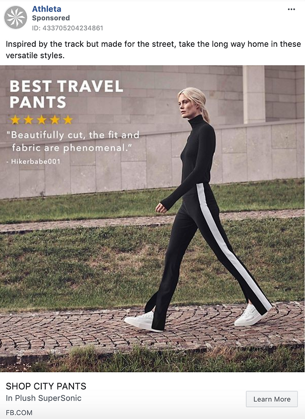 A woman walks outside wearing black pants with white side stripes, a black turtleneck, and white sneakers against a muted urban background. Text reads “Best Travel Pants.”.