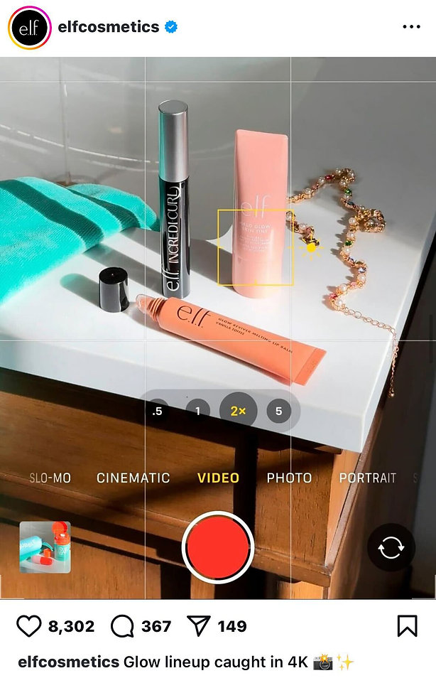 Three e.l.f. cosmetics products and a gold chain are displayed on a white surface beside a teal towel, with a phone camera interface overlay.