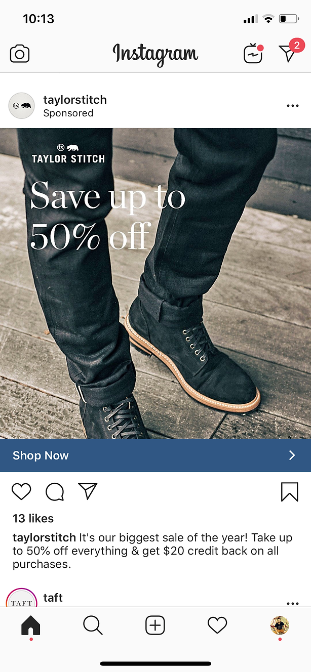 Person wearing black pants and black boots standing on a light-colored surface, with text overlay promoting a Taylor Stitch sale of up to 50% off.