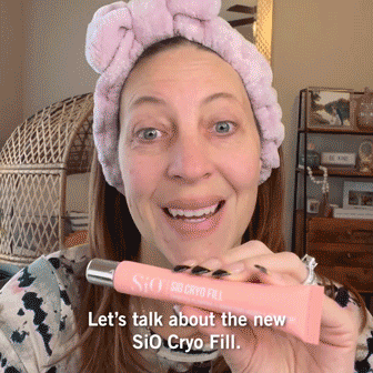 A woman wearing a pink headband holds up a tube labeled "SiO Cryo Fill" and speaks to the camera. Text on image reads: "Let's talk about the new SiO Cryo Fill.