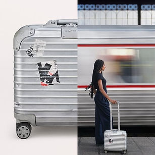 A silver hard-shell suitcase with stickers is shown on the left; on the right, a woman stands with the same suitcase near a train in motion.