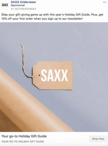 A brown gift tag labeled "SAXX" hangs by a string on a plain, light-colored background; ad text promotes a holiday gift guide and discount offer.