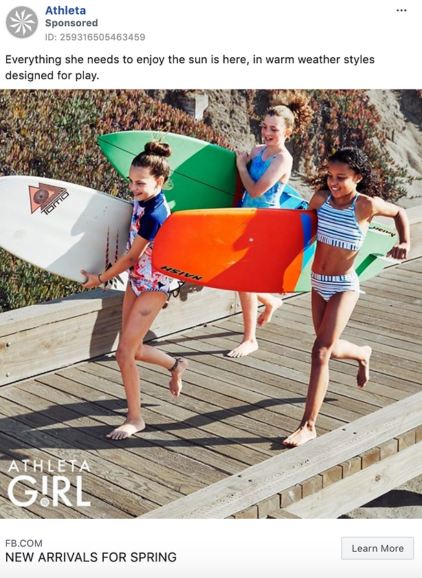 Three girls in swimsuits walk on a wooden boardwalk carrying surfboards, smiling and heading toward the beach.