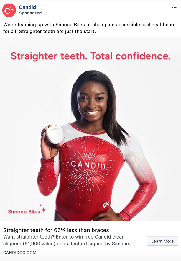 Simone Biles stands smiling in a red leotard, holding a case of clear aligners, with the text “Straighter teeth. Total confidence.” and Candid branding in the background.