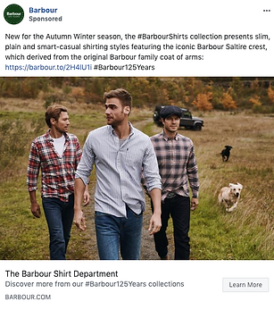 Three men wearing Barbour shirts walk outdoors in a grassy, rural landscape with an off-road vehicle in the background.