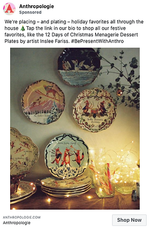 Five decorative holiday plates with festive animal designs are displayed on a wall above a table with string lights, glassware, and holiday decor.
