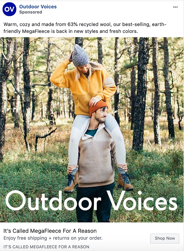 A woman in a yellow fleece sits on a man's shoulders outdoors; both wear beanies and fleece tops in a grassy area. Text promotes Outdoor Voices' recycled wool MegaFleece clothing.