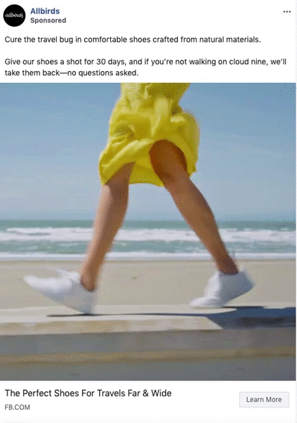 Person wearing a yellow dress and white sneakers walks along a beach boardwalk, with the ocean and sky in the background.