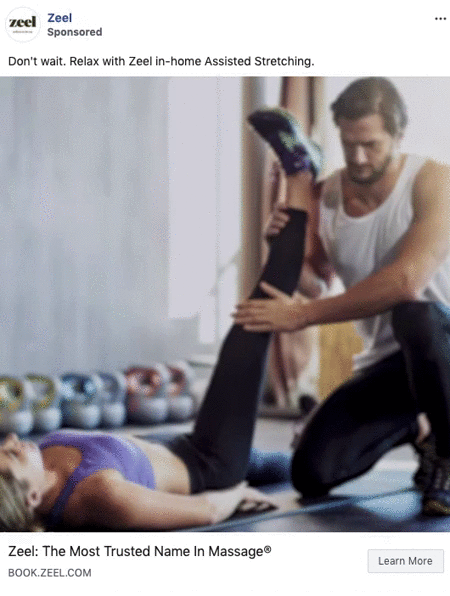 A man assists a woman with a leg stretch on a mat in a gym-like setting, with exercise equipment visible in the background.