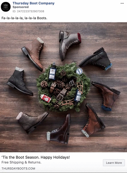 A wreath with ornaments and gift items is surrounded by eight pairs of men’s leather boots arranged in a circle on a wooden floor.