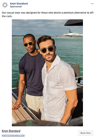 Two men wearing sunglasses and casual clothing stand on a boat deck with water and a city skyline in the background.