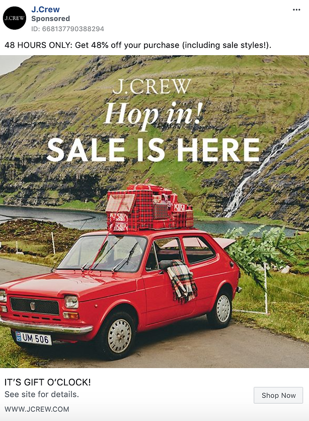 A red vintage car with a plaid blanket and baskets on top is parked on grass in front of a hilly landscape; text promotes a J.Crew sale with a 48% discount.