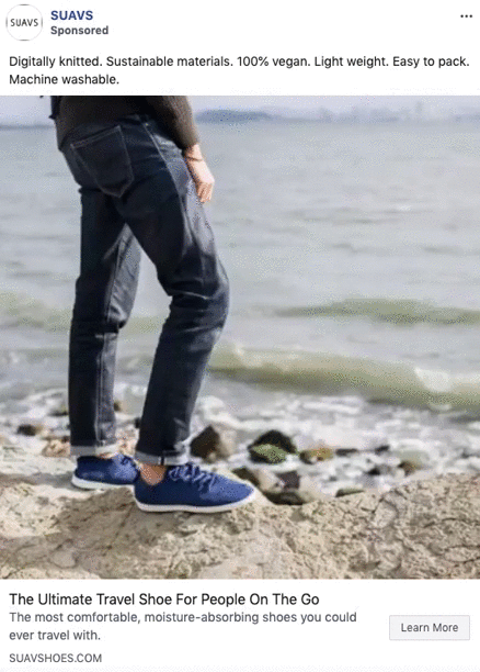 Person wearing blue sneakers and dark jeans stands on a rocky shoreline with water in the background. Text promotes lightweight, vegan, and sustainable travel shoes.