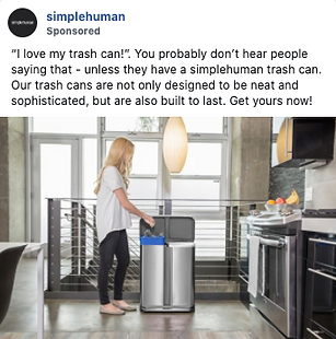 A woman stands in a modern kitchen placing trash into a stainless steel dual-compartment simplehuman trash can.