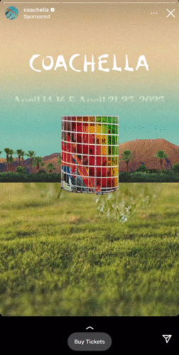 A colorful cylindrical art installation stands in a field with palm trees and mountains in the background. Text reads, "Coachella April 14-16 & April 21-23, 2023.